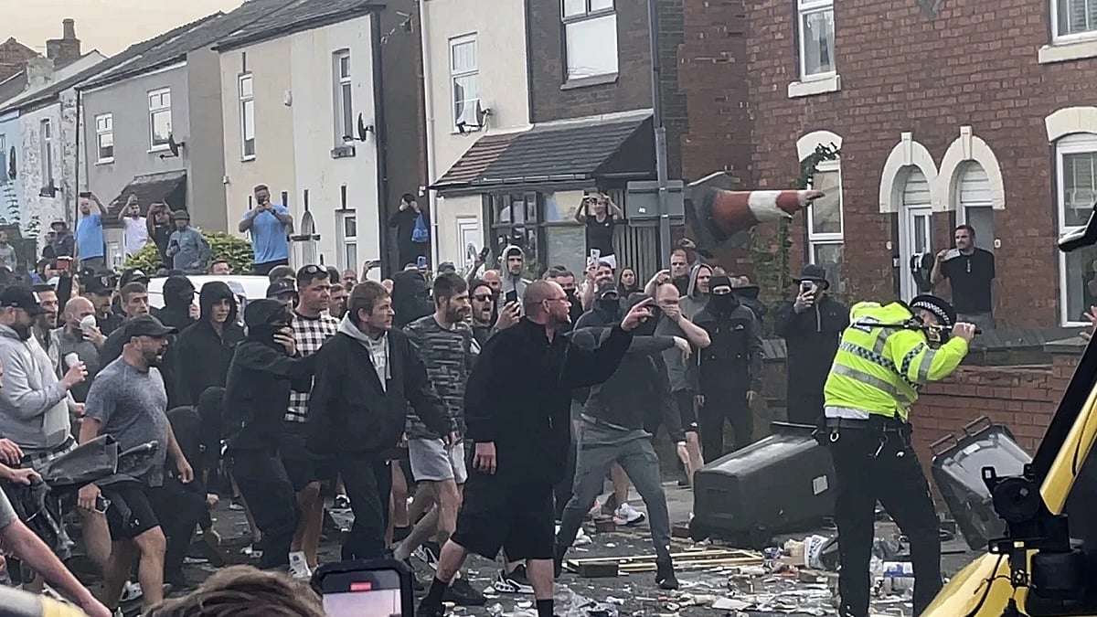 AP : An unruly crowd clash with police in  Southport |